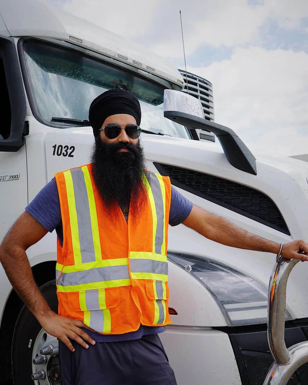 An owner-operator standing beside his truck